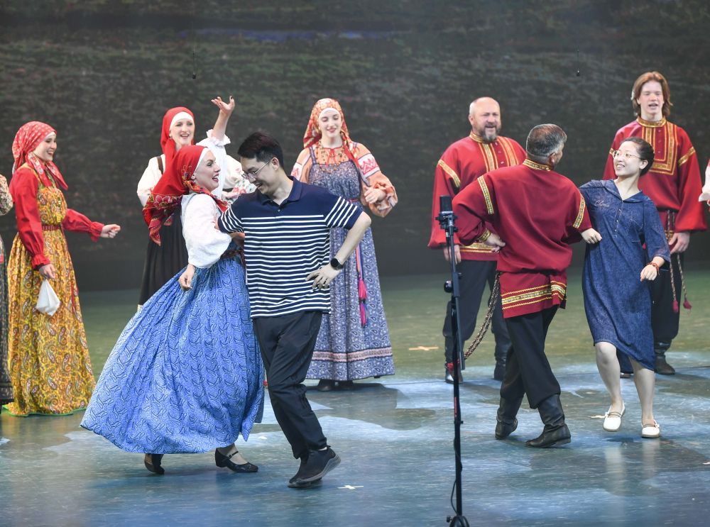 　　在乌鲁木齐晚报剧院，俄罗斯萨拉托夫州曙光歌舞团的演员们邀请现场观众同台共舞（7月22日摄）。新华社记者 胡虎虎 摄